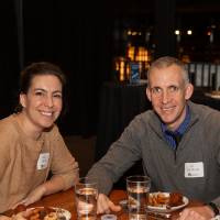 two alumni smile for a picture